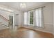 Bright living room featuring hardwood floors, detailed trim, and views to the staircase and front door at 1601 Castalia Dr, Cary, NC 27513