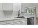 Modern kitchen with white cabinets, countertops, stainless steel appliances, and a tiled backsplash at 1723 Kudrow Ln, Morrisville, NC 27560