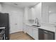 Modern kitchen with white cabinets, countertops, stainless steel appliances, and wood-style flooring at 1723 Kudrow Ln, Morrisville, NC 27560