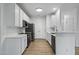 Modern kitchen with white cabinets, countertops, stainless steel appliances, and wood-style flooring at 1723 Kudrow Ln, Morrisville, NC 27560
