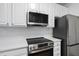 Modern kitchen featuring stainless steel appliances, sleek white cabinetry, and a contemporary backsplash at 1723 Kudrow Ln, Morrisville, NC 27560