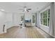 Bright living room featuring wood floors, a ceiling fan, and large windows offering natural light at 1723 Kudrow Ln, Morrisville, NC 27560