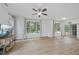 Bright living room with wood floors, ceiling fan, large windows, and a glass sliding door at 1723 Kudrow Ln, Morrisville, NC 27560