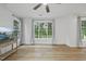 Bright living room featuring wood floors, a ceiling fan, and large windows offering natural light at 1723 Kudrow Ln, Morrisville, NC 27560