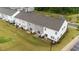 Aerial view of townhome backyards with sliding glass doors, patios, and adjacent pond at 19 Willow Green Dr, Clayton, NC 27527