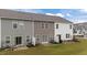 View of townhome backyards with sliding glass doors, patios, and green lawns at 19 Willow Green Dr, Clayton, NC 27527