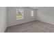 The sunny bedroom features two windows, a neutral carpet, and base molding at 19 Willow Green Dr, Clayton, NC 27527