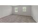 Bright bedroom featuring two windows, a neutral carpet, and base molding at 19 Willow Green Dr, Clayton, NC 27527