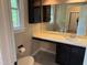 Bathroom with a vanity, sink, a large mirror and tile floors plus a window for natural light at 200 W Woodcroft Pkwy # 52A, Durham, NC 27713
