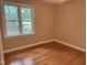Cozy bedroom showcasing hardwood floors, neutral walls, and natural light from the window at 200 W Woodcroft Pkwy # 52A, Durham, NC 27713