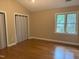 Bright bedroom featuring hardwood floors, a large window, neutral walls, and closet at 200 W Woodcroft Pkwy # 52A, Durham, NC 27713