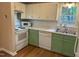 Modern kitchen with white cabinets, stainless steel appliances, and a double sink under a window at 200 W Woodcroft Pkwy # 52A, Durham, NC 27713