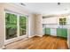 Eat-in kitchen with two tone cabinetry, great light, white subway tile, and wood look floors at 200 W Woodcroft Pkwy # 52A, Durham, NC 27713