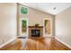 Cozy living room featuring a brick fireplace, wood floors, and natural light from large windows at 200 W Woodcroft Pkwy # 52A, Durham, NC 27713