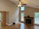 Bright living room featuring hardwood floors, a ceiling fan, and a brick fireplace leading to an outdoor deck at 200 W Woodcroft Pkwy # 52A, Durham, NC 27713