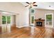 Bright living room with hardwood floors, a brick fireplace, and large windows at 200 W Woodcroft Pkwy # 52A, Durham, NC 27713