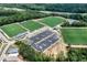 Aerial view of the community sports park with soccer fields, tennis courts, parking lots, and surrounding green space at 2003 Pilot Mountain Ct, Apex, NC 27502