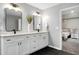 Bright bathroom featuring double vanity sinks, modern lighting, and a glass-enclosed shower, steps away from the bedroom at 2003 Pilot Mountain Ct, Apex, NC 27502