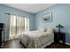 Cozy bedroom featuring soft blue walls, bright windows, and comfortable furnishings at 2003 Pilot Mountain Ct, Apex, NC 27502