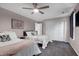 Bright bedroom with two beds, ceiling fan, closet, gray carpet, and soft pink wall color at 2003 Pilot Mountain Ct, Apex, NC 27502