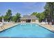 Community pool with lounge chairs, umbrellas, and a view of the clubhouse at 2003 Pilot Mountain Ct, Apex, NC 27502