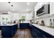 Bright, modern kitchen with two-tone cabinets, stainless appliances, and marble countertops at 2003 Pilot Mountain Ct, Apex, NC 27502
