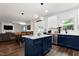 Open-concept kitchen with a large island, stainless steel appliances, and modern lighting fixtures at 2003 Pilot Mountain Ct, Apex, NC 27502