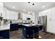 Kitchen featuring white cabinets, navy blue island with seating, and stainless appliances at 2003 Pilot Mountain Ct, Apex, NC 27502