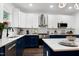 Bright kitchen with white cabinets, navy countertops, stainless appliances, and modern finishes at 2003 Pilot Mountain Ct, Apex, NC 27502