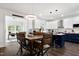 Bright open kitchen with white cabinets, navy island, and stylish dining area at 2003 Pilot Mountain Ct, Apex, NC 27502
