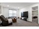 Cozy living room features neutral walls, plush carpeting, and comfortable seating with an opening leading to a bedroom at 2003 Pilot Mountain Ct, Apex, NC 27502