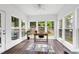 Bright sunroom with large windows overlooking a fenced yard and wood-look flooring at 2003 Pilot Mountain Ct, Apex, NC 27502