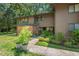 Two-story townhouse featuring a landscaped yard, mature trees, and inviting front entrance with brick and wood accents at 202 Oak Tree Dr, Chapel Hill, NC 27517