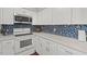 Bright kitchen featuring stainless appliances, stone countertops, and white cabinets at 202 Oak Tree Dr, Chapel Hill, NC 27517