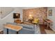 Comfortable living room featuring a sofa, exposed brick, hardwood floors, and natural light at 202 Oak Tree Dr, Chapel Hill, NC 27517