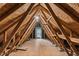 Unfinished attic with exposed wooden beams and a small window at 2030 Prairie Ridge Ct, Fuquay Varina, NC 27526