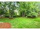 Beautiful backyard featuring a well-manicured lawn and mature trees, creating a serene outdoor space at 2030 Prairie Ridge Ct, Fuquay Varina, NC 27526