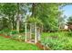Scenic view of a backyard garden with a white trellis gate, adding a touch of elegance to the landscape at 2030 Prairie Ridge Ct, Fuquay Varina, NC 27526