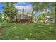 Expansive backyard featuring a large deck, lush lawn, mature trees, and partial view of a neighboring home at 2030 Prairie Ridge Ct, Fuquay Varina, NC 27526