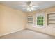 Bedroom featuring built-in shelving and storage surrounding a window with backyard views and a ceiling fan at 2030 Prairie Ridge Ct, Fuquay Varina, NC 27526