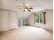 Bedroom featuring neutral carpet, a ceiling fan, built-in shelving and window with backyard views at 2030 Prairie Ridge Ct, Fuquay Varina, NC 27526