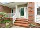 Inviting front porch with brick steps, white railings, and a charming entrance, offering a warm welcome at 2030 Prairie Ridge Ct, Fuquay Varina, NC 27526