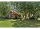 Charming brick home with a manicured front lawn, mature trees, and a welcoming porch and partial sidelight windows at 2030 Prairie Ridge Ct, Fuquay Varina, NC 27526