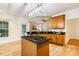 Bright kitchen featuring wood cabinets, dark countertops, stainless steel appliances, and an open floor plan at 2030 Prairie Ridge Ct, Fuquay Varina, NC 27526