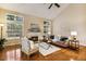 Bright living room featuring a fireplace, large windows, hardwood floors, and comfortable seating area at 2030 Prairie Ridge Ct, Fuquay Varina, NC 27526