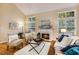 Cozy living room with a fireplace, large windows, hardwood floors, and comfortable seating arrangement at 2030 Prairie Ridge Ct, Fuquay Varina, NC 27526