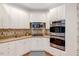 Eat-in kitchen showcases white cabinetry, stainless steel appliances and sleek countertops for a modern look at 204 Middlestone Ct, Wake Forest, NC 27587