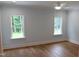 A clean, spacious bedroom features wood floors and two bright windows at 2112 Coy St, Burlington, NC 27215