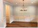Dining room featuring wood floors, elegant lighting, and wainscoting at 2112 Coy St, Burlington, NC 27215