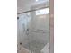 Luxurious walk-in shower with floor-to-ceiling marble tile and glass door at 2112 Coy St, Burlington, NC 27215